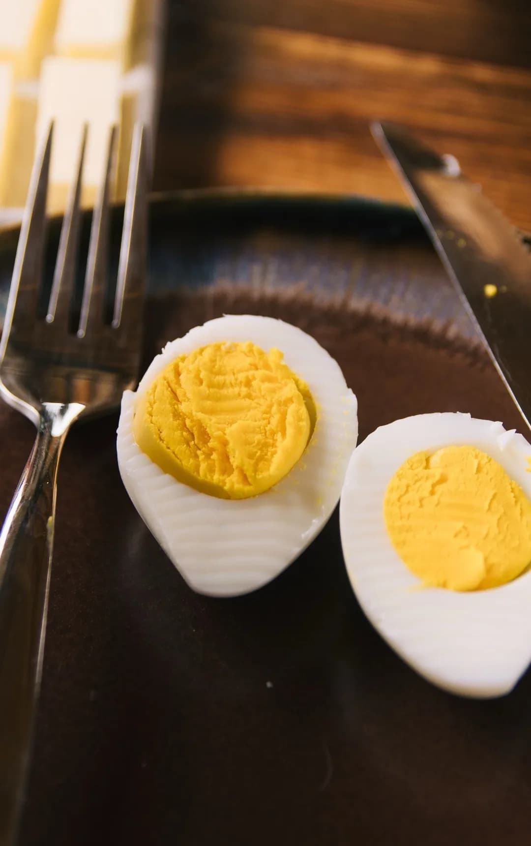 Halved hard-boiled eggs on a dark plate